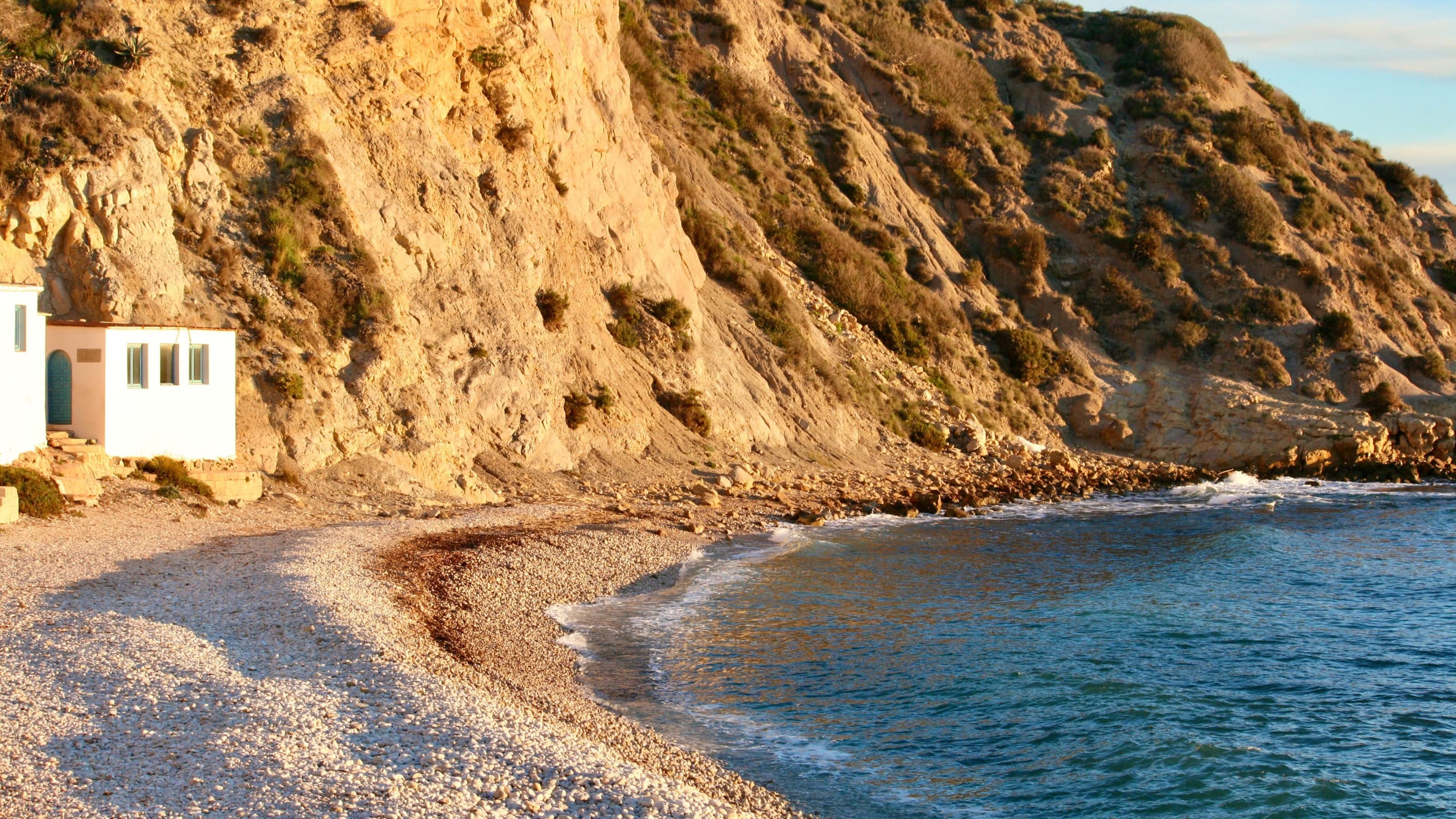 La caseta blanca de pescadores con puerta azul de la cala del Portitxol, en Xàbia, al amanecer
